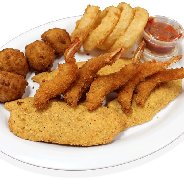 Fried fish, shrimp, hush puppies, and onion rings with dipping sauce on a white plate.
